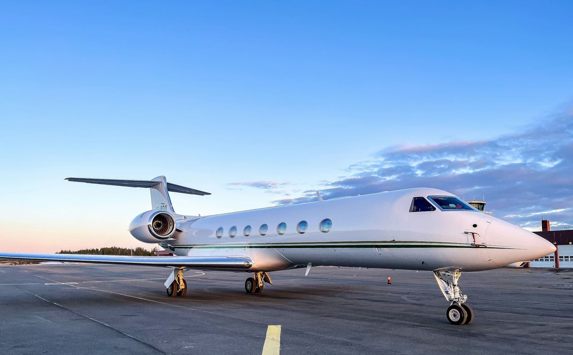 A large-cabin business jet parked on the apron